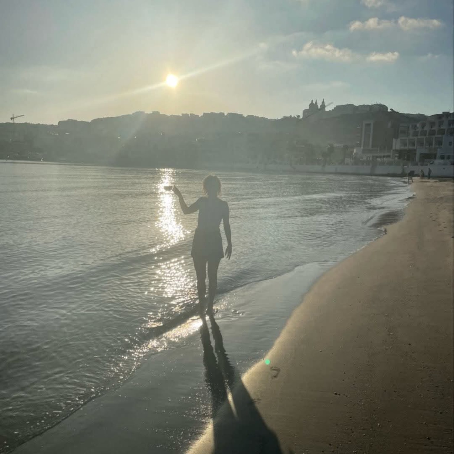 Paulina walking at the shoreline in warm evening sunlight