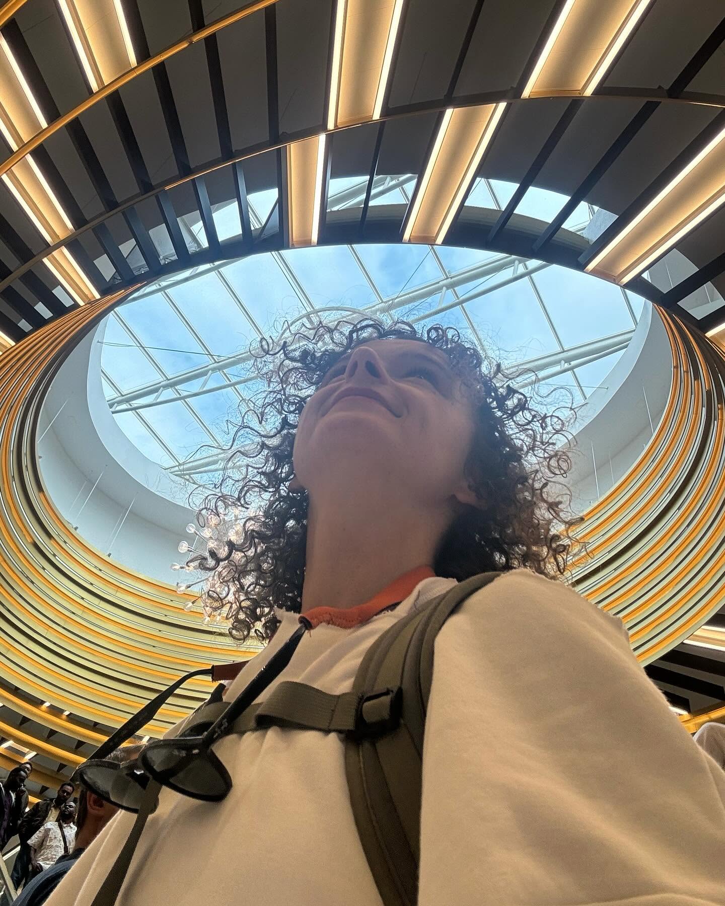 Paulina Peliwo looking upward beneath circular architecture, reflecting perspective and personal growth